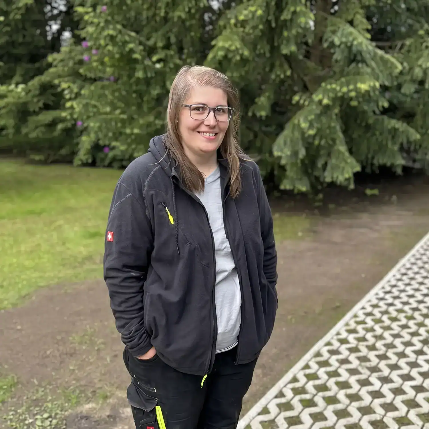 Ansprechpartnerin von Gröting Garten- und Landschaftsbau in Dorsten vor einer gepflegten Außenanlage